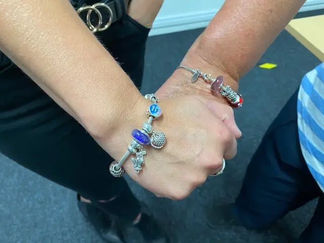 Dave's wife Sylvia and daughter Paula with their bracelet charms made with his ashes