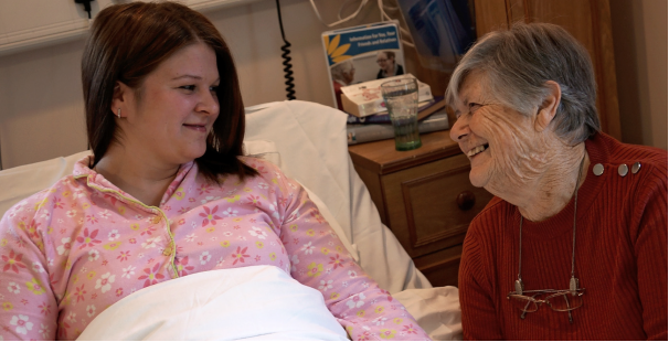 Woman in hospice bed with family member