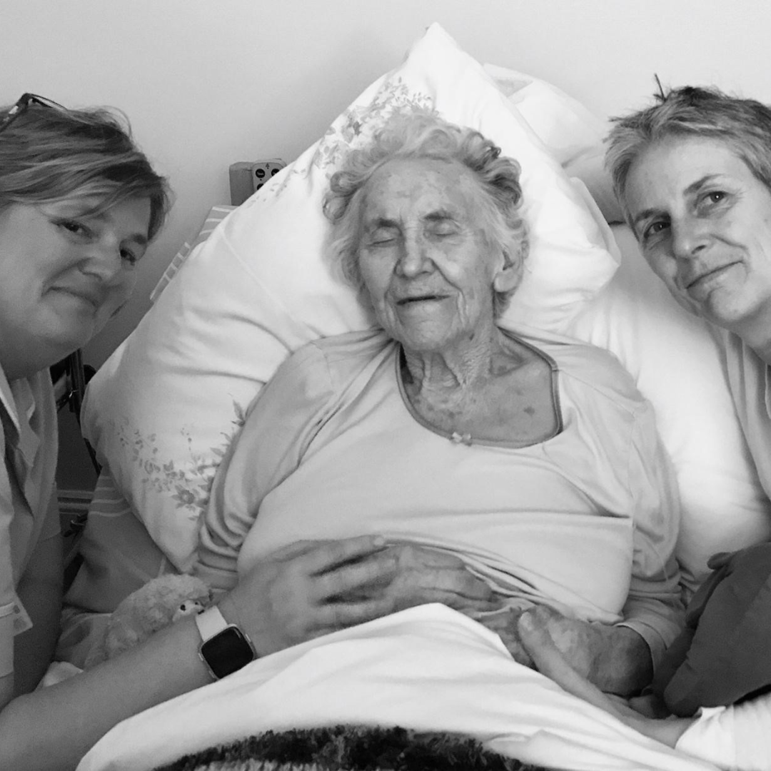 Woman in Hospice with nurse and family member