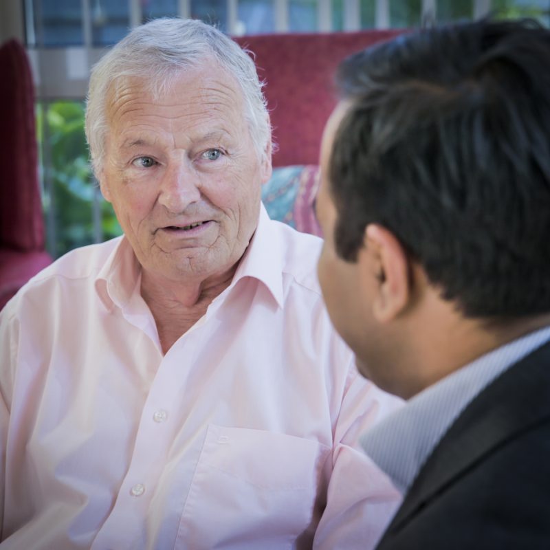 A doctor talking with an older male patient